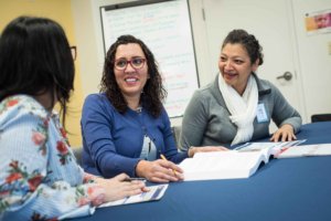 This is a photo of three women talking at Project Access-New Haven's office.